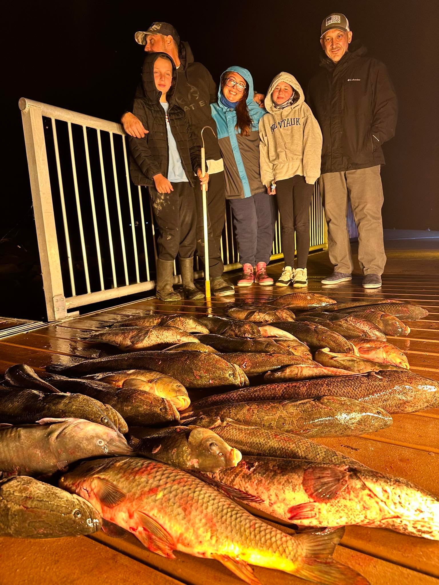 Bowfishing catch laid out on the boat deck at night