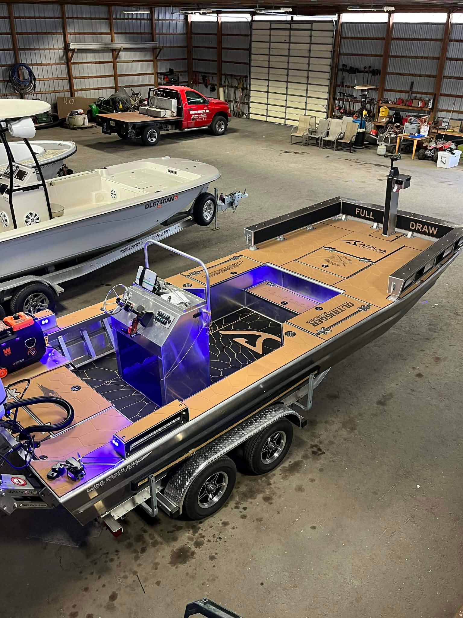Full Draw Bowfishing's custom 20-foot Long Beach bowfishing boat on its trailer in the shop