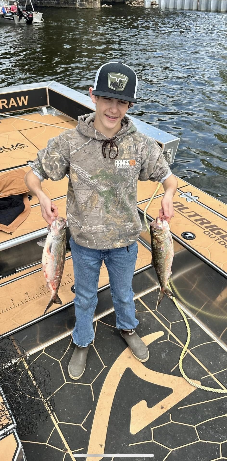 Angler holding an American Shad on the boat